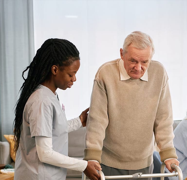 assisting elderly man with walker in care home set
